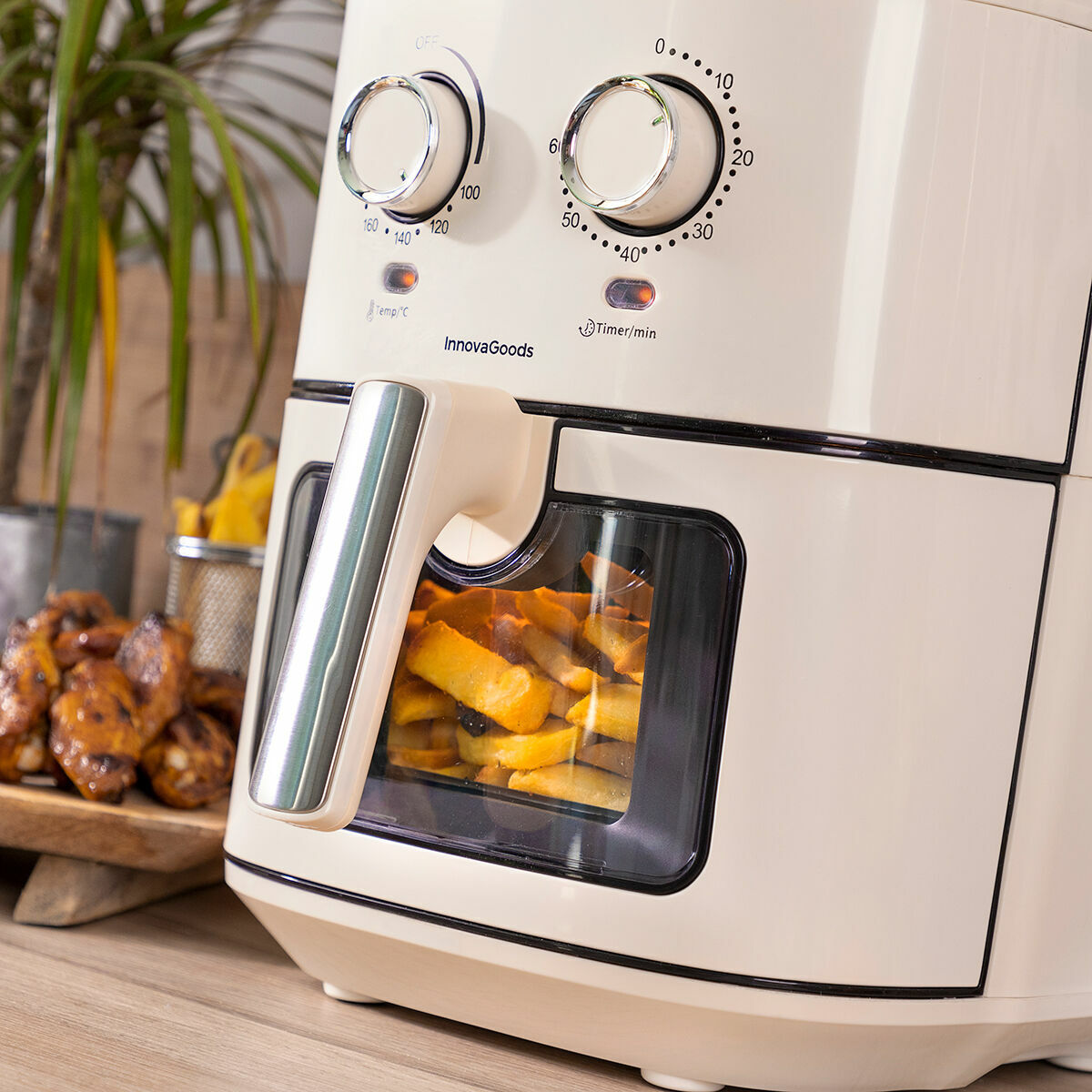 InnovaGoods air fryer with food inside on a wooden surface