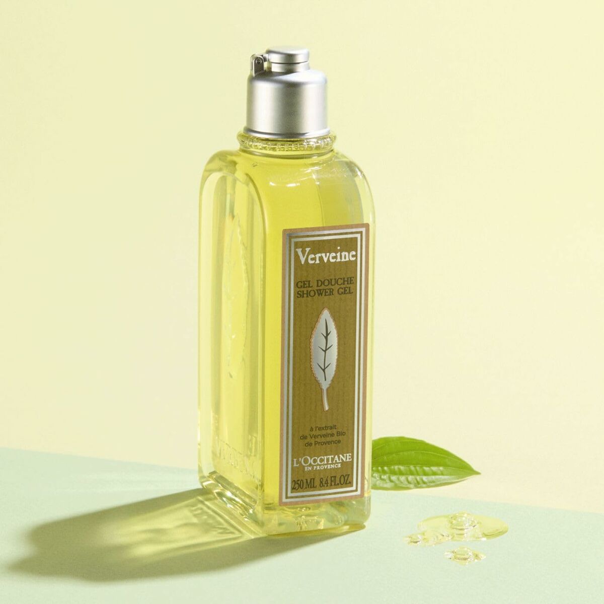 L'Occitane Verveine shower gel bottle on a light green background