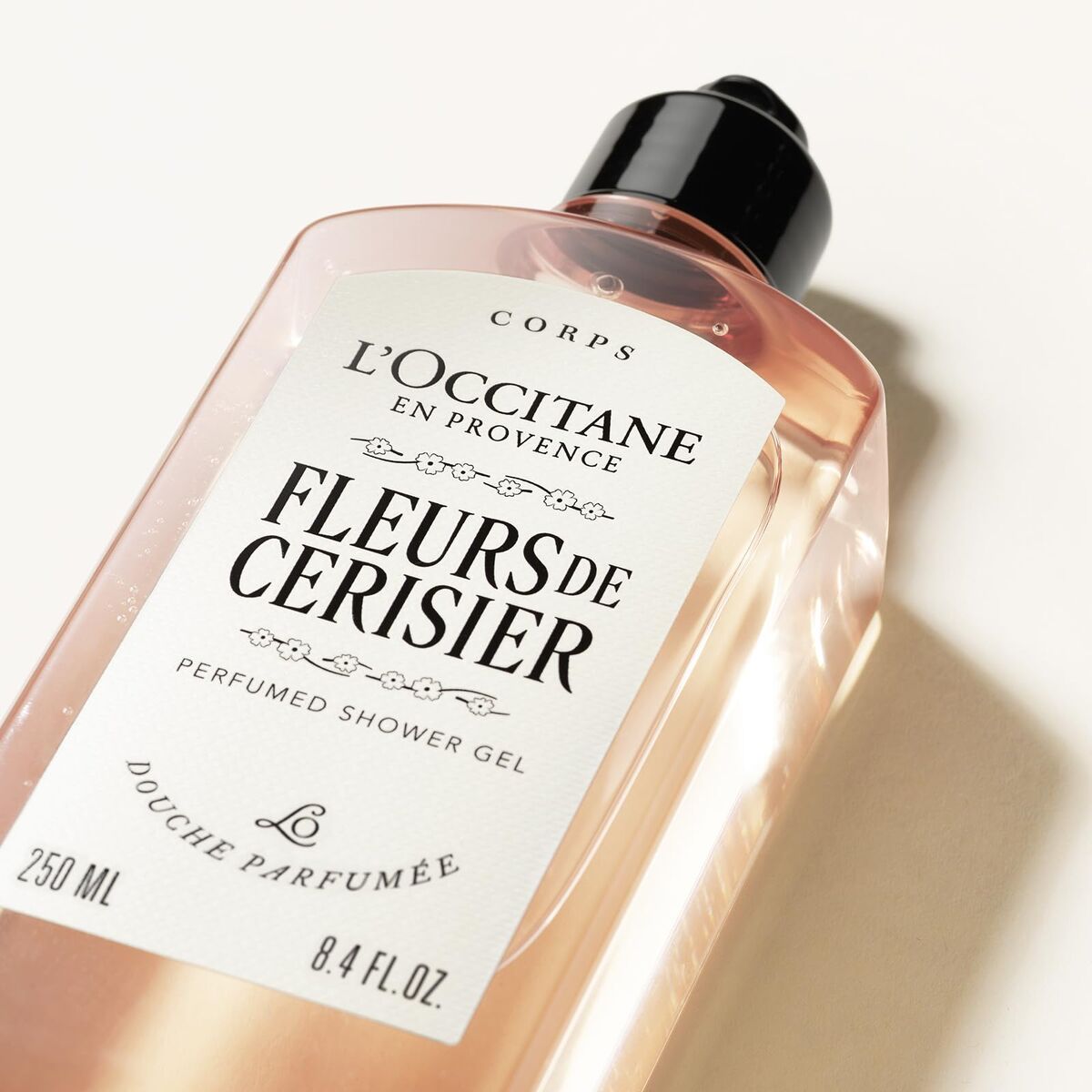 L'Occitane Fleurs de Cerisier shower gel bottle on a light background