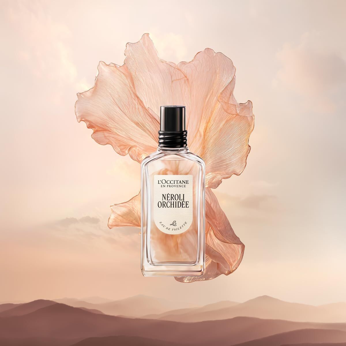 L'Occitane Neroli Orchidee perfume bottle with a large pink flower on a soft background