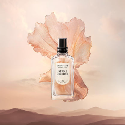 L'Occitane Neroli Orchidee perfume bottle with a large pink flower on a soft background