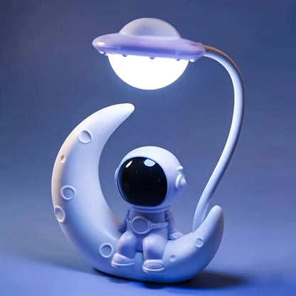 Decorative lamp with an astronaut on a moon and a UFO above, on a blue background