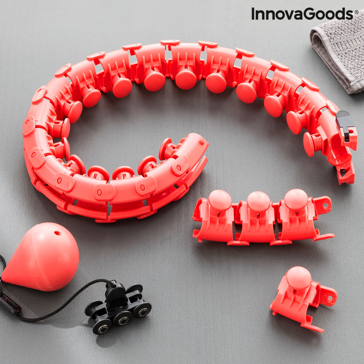 Red plastic toy track set with components on a gray surface, featuring the InnovaGoods brand.