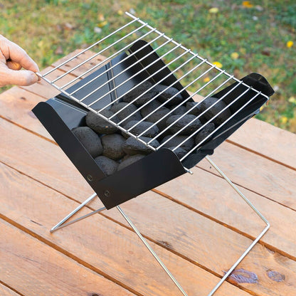 Portable grill with charcoal on a wooden surface outdoors
