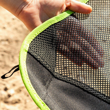 Close-up of a hand holding a black mesh bag with green trim.