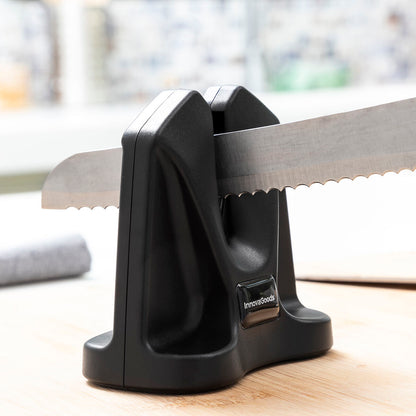 Knife sharpener with a serrated knife on a wooden surface