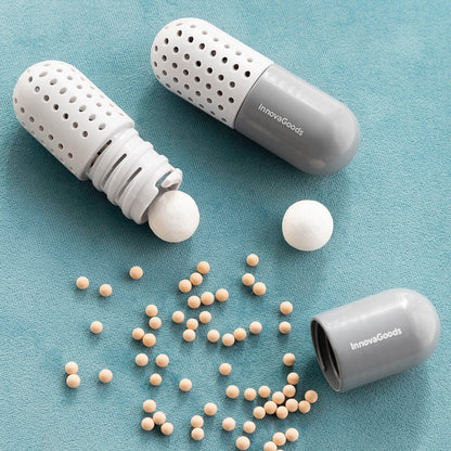 Two gray and white pill organizers with balls on a blue background, branded 'InnovoGoods'.