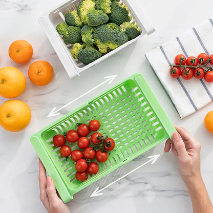 Green plastic basket with tomatoes on a marble surface with oranges, broccoli, and a towel.