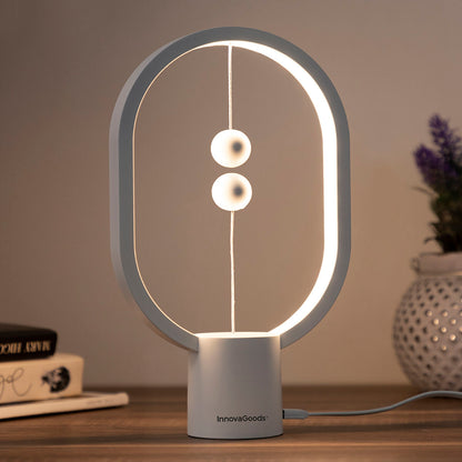 Modern table lamp with circular design on a wooden surface, featuring the brand 'innovaGoods'.